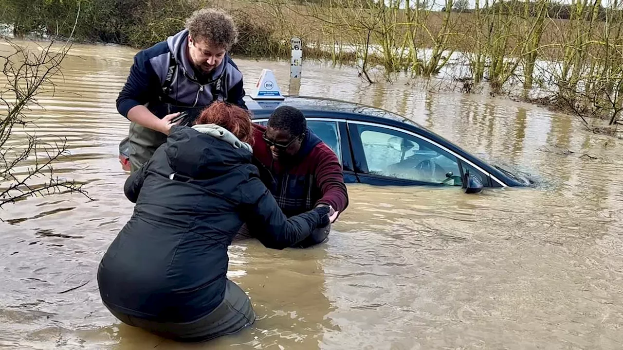 Couple rescue trapped driving instructor from 4ft of floodwater while emergency crews STAND BY -...