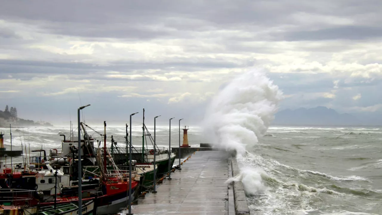 Wave sweeps toddler in a stroller into harbour waters at Kalk Bay