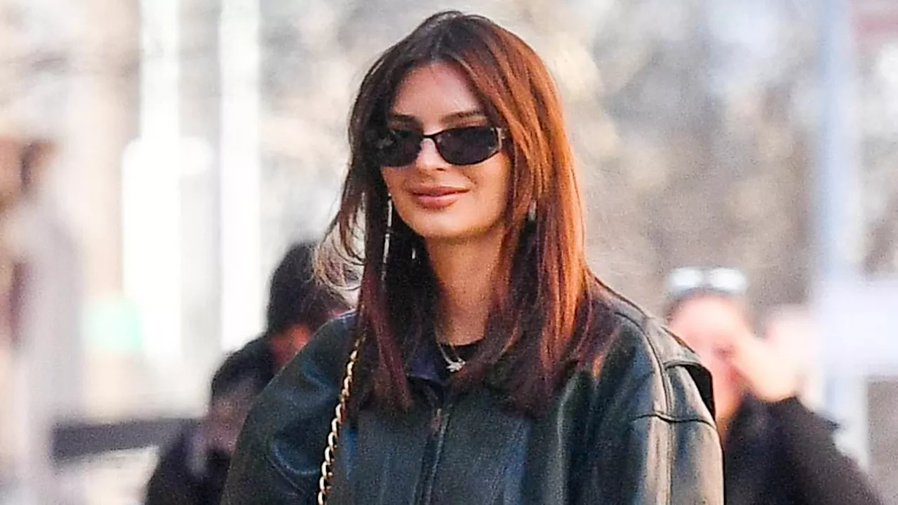 Emily Ratajkowski puts on a stylish display in oversize leather bomber jacket and asymmetrical skirt...