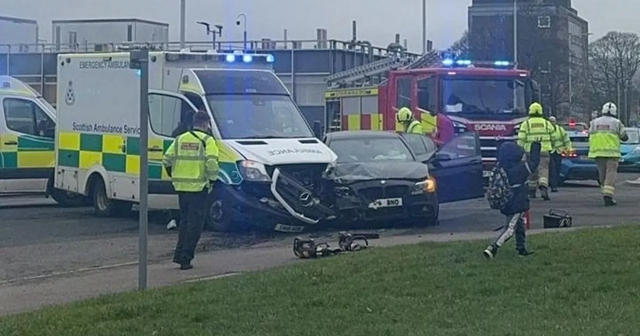 Woman trapped in car after crash with ambulance carrying patient near hospital