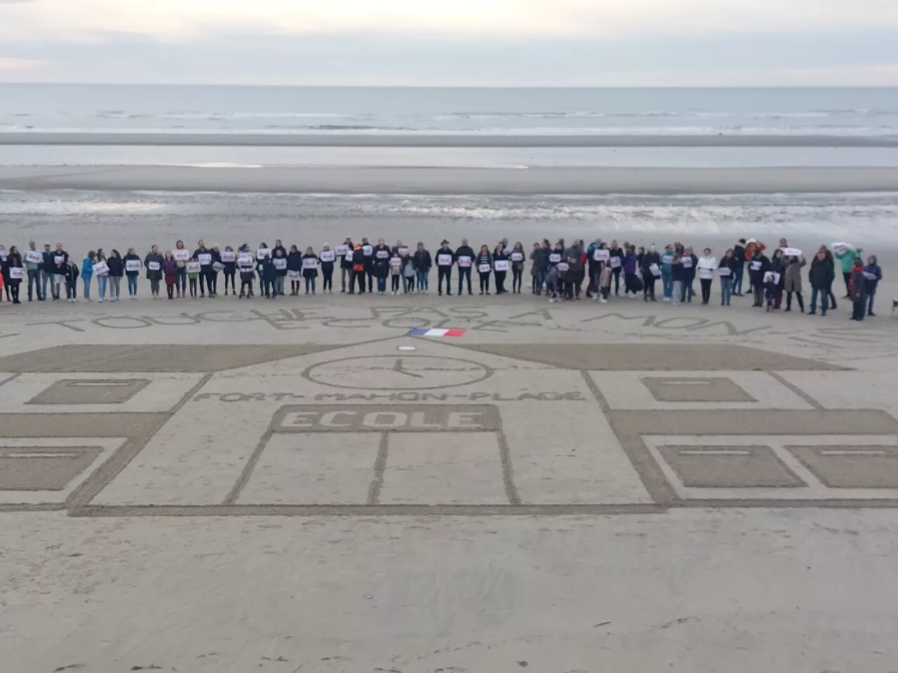 Une école dessinée sur le sable pour protester contre la fermeture d'une classe