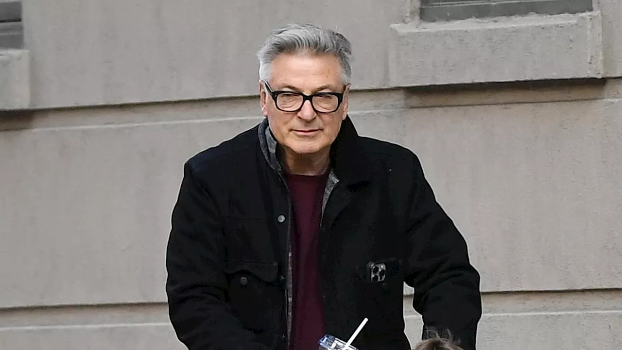 Alec Baldwin looks somber as he steps out with two of his children in NYC