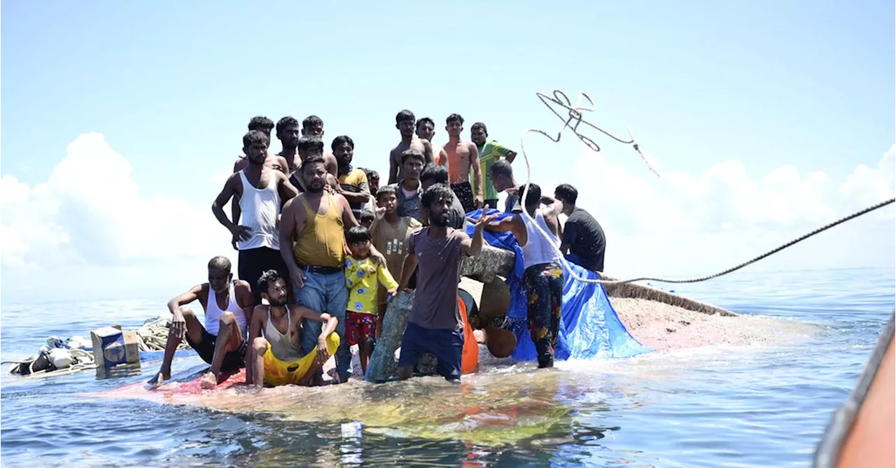 Weeping, weak and soaked, dozens of refugees rescued after night on hull of capsized boat