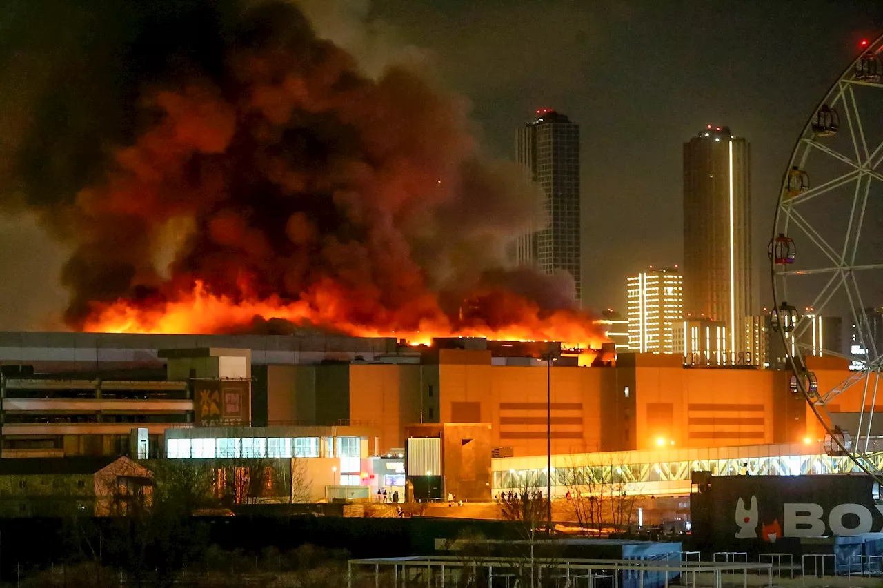 Gunmen in combat fatigues fire on crowds at a Moscow concert hall which is now ablaze