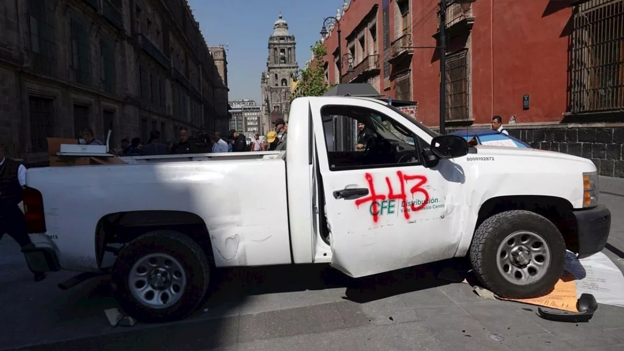 Palacio Nacional: encapuchados del movimiento Ayotzinapa derriban puerta durante mañanera de AMLO