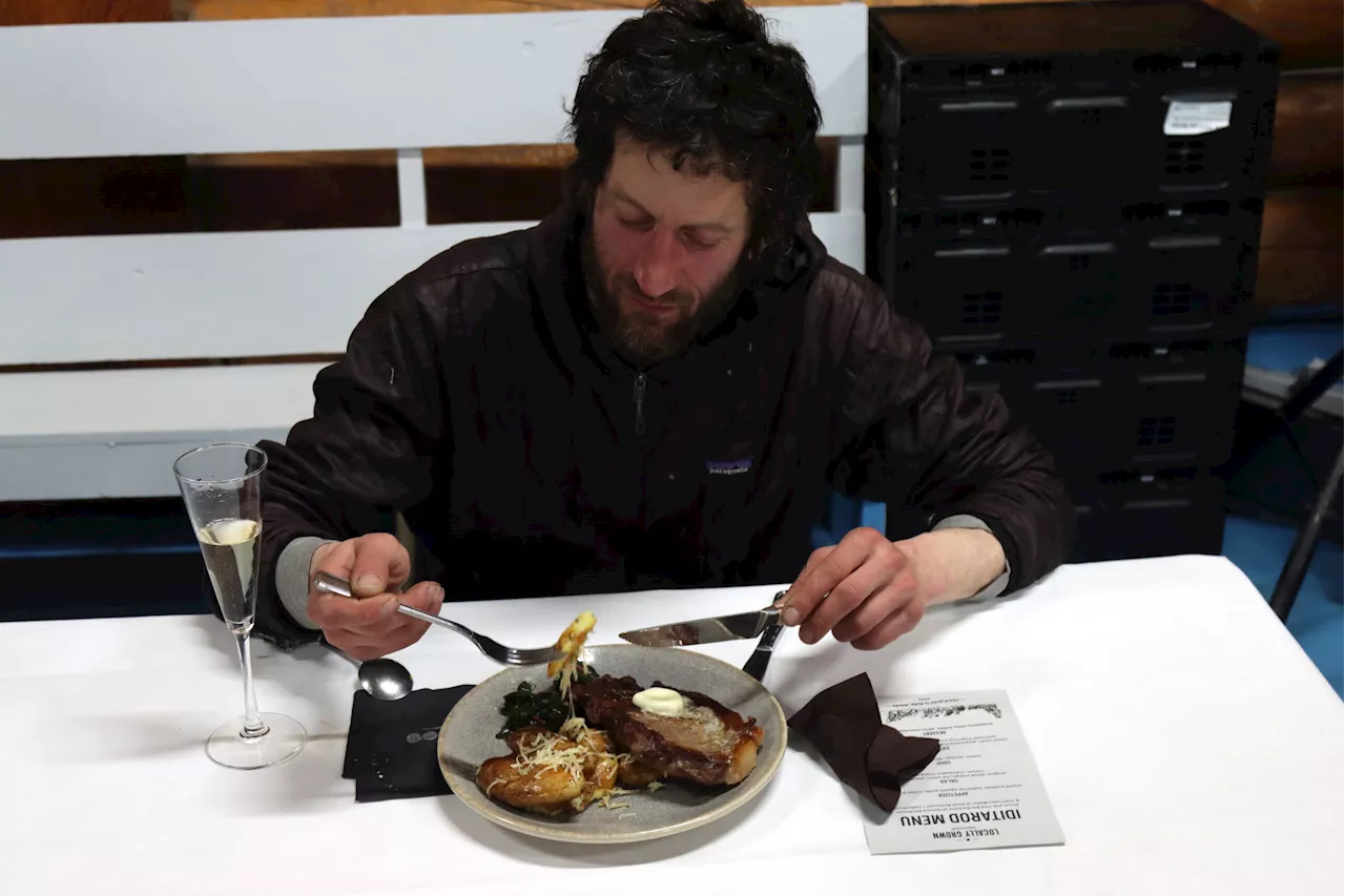 Iditarod musher Petit and his dogs chow down in Ruby after arriving first to the Yukon River town