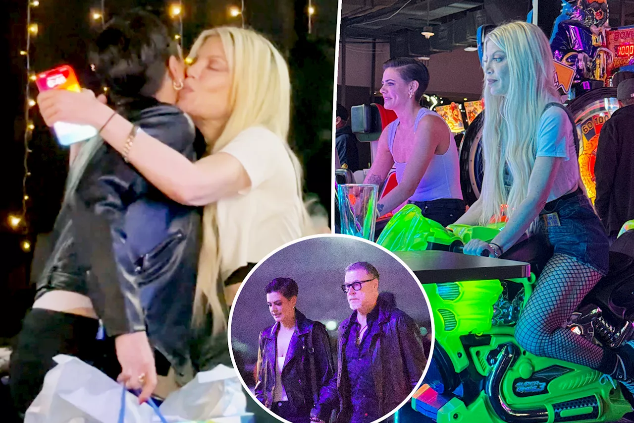 Tori Spelling gives ex Dean McDermott's girlfriend, Lily Calo, a hug and kiss during amicable arcade outing