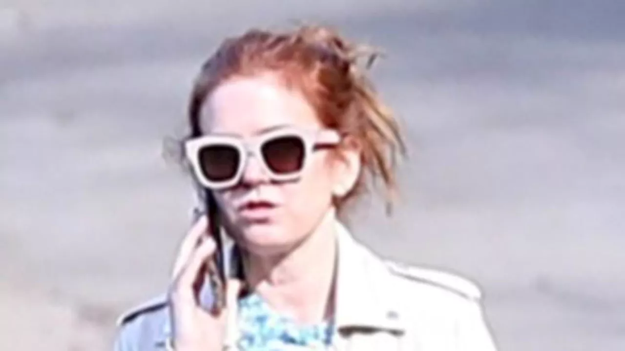 Isla Fisher removes wedding ring and takes an animated phone call in first sighting since revealing...