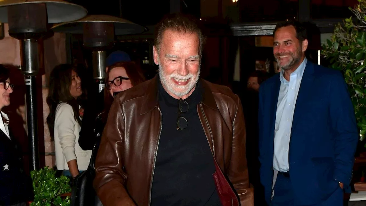 Arnold Schwarzenegger, 76, rocks white beard and brown leather jacket as he appears in high spirits...