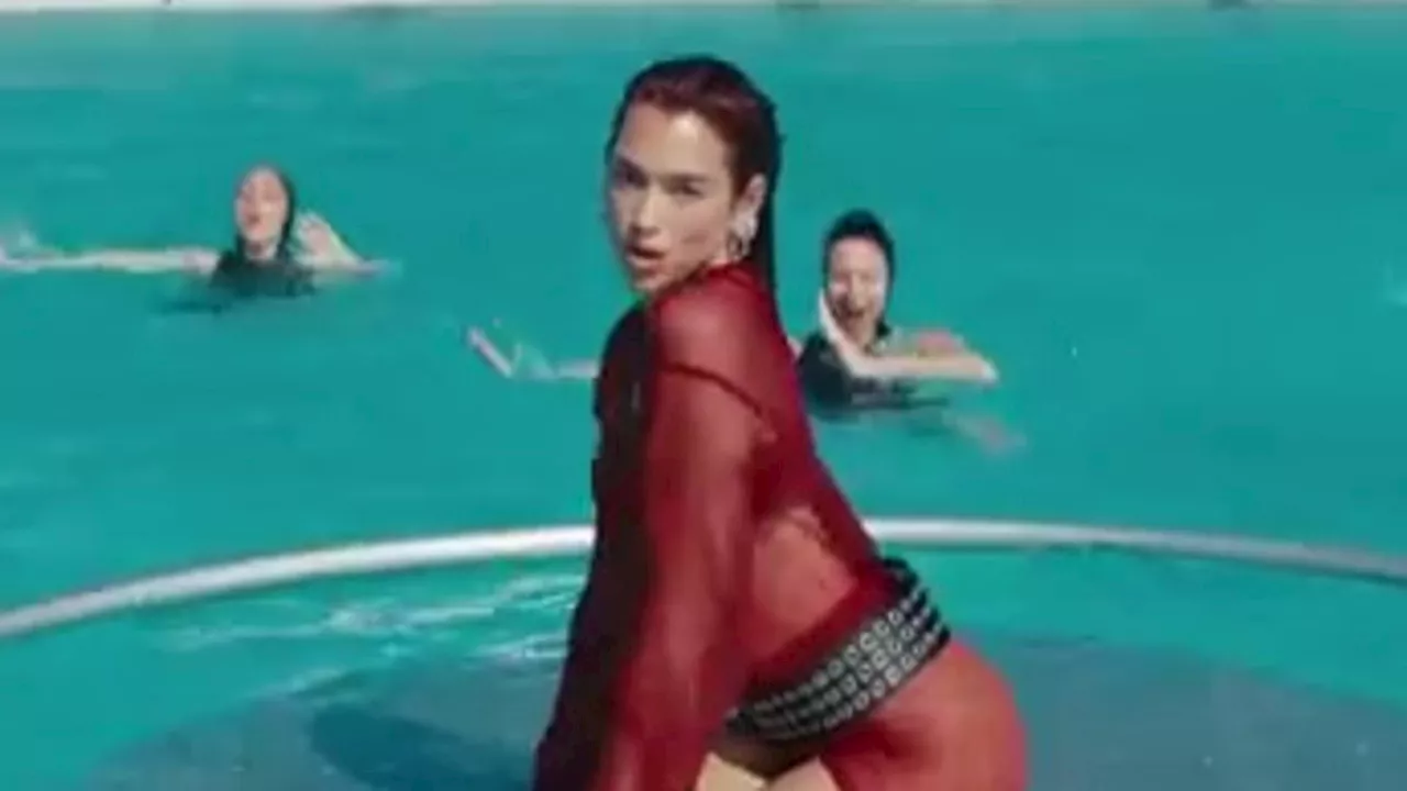 Dua Lipa is red hot in fiery mesh dress as she writhes around in a pool with synchronized swimmers...