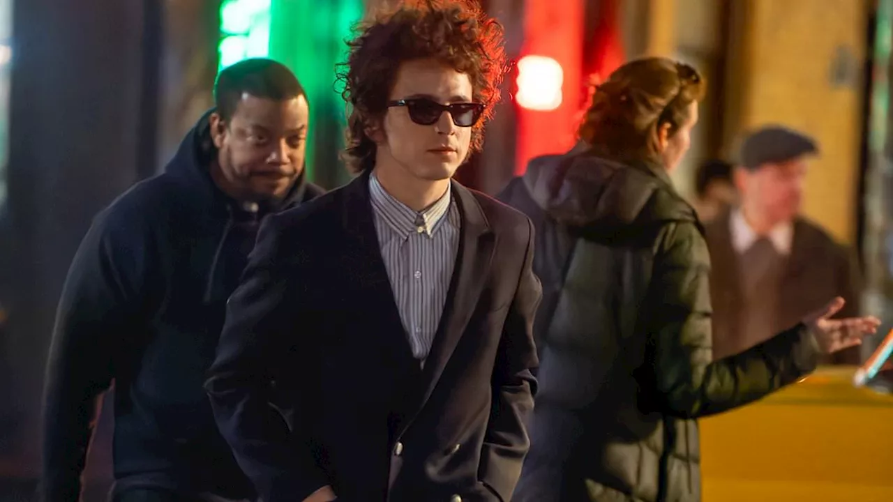 Timothee Chalamet wears his sunglasses at night while filming the Bob Dylan biopic A Complete...