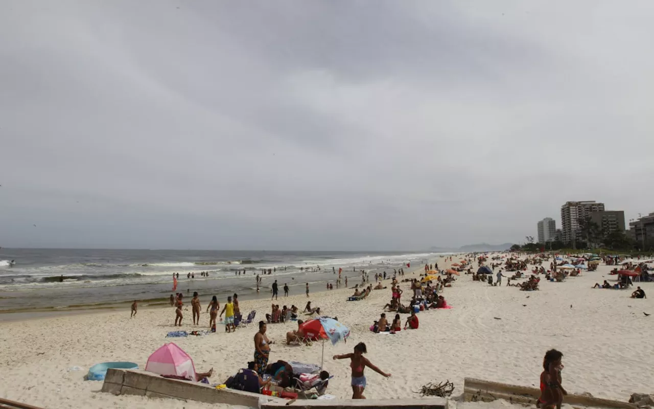 Cariocas aproveitam praia da Barra da Tijuca durante dia de tempo encoberto