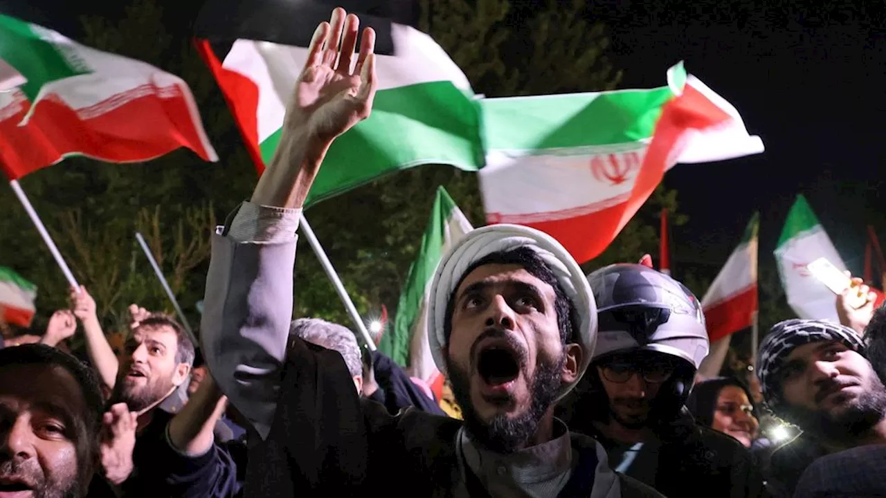 Demonstrators in Tehran raise Iranian and Palestinian flags in front of the British Embassy