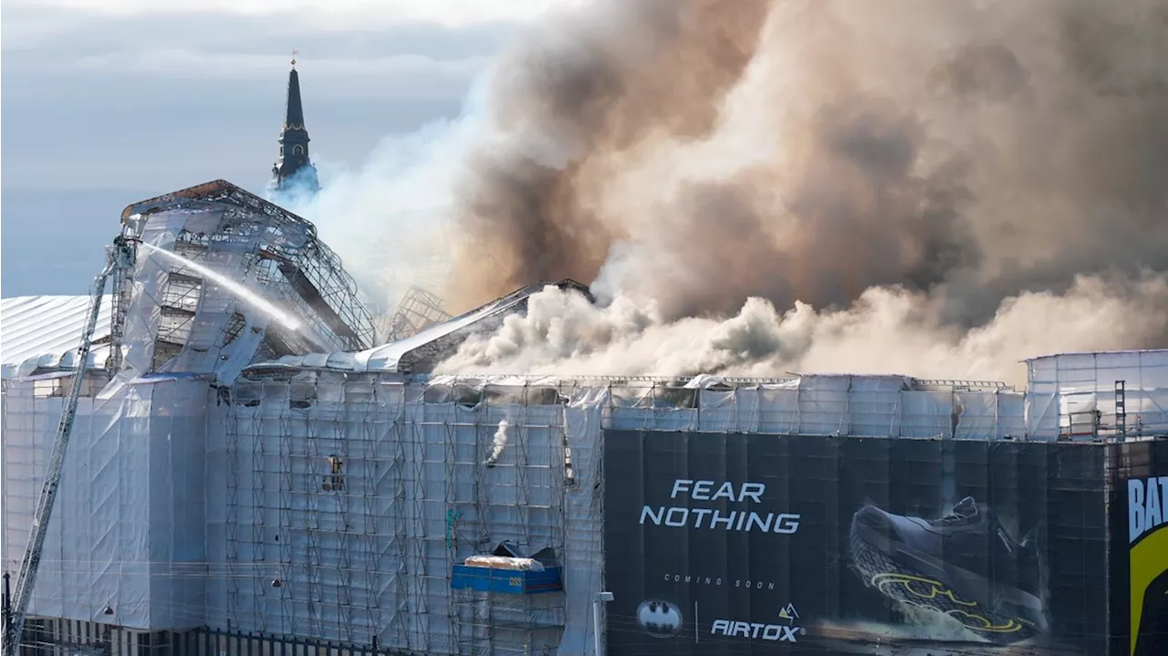 Fire rages through the 17th-century Old Stock Exchange in Copenhagen, toppling the iconic spire