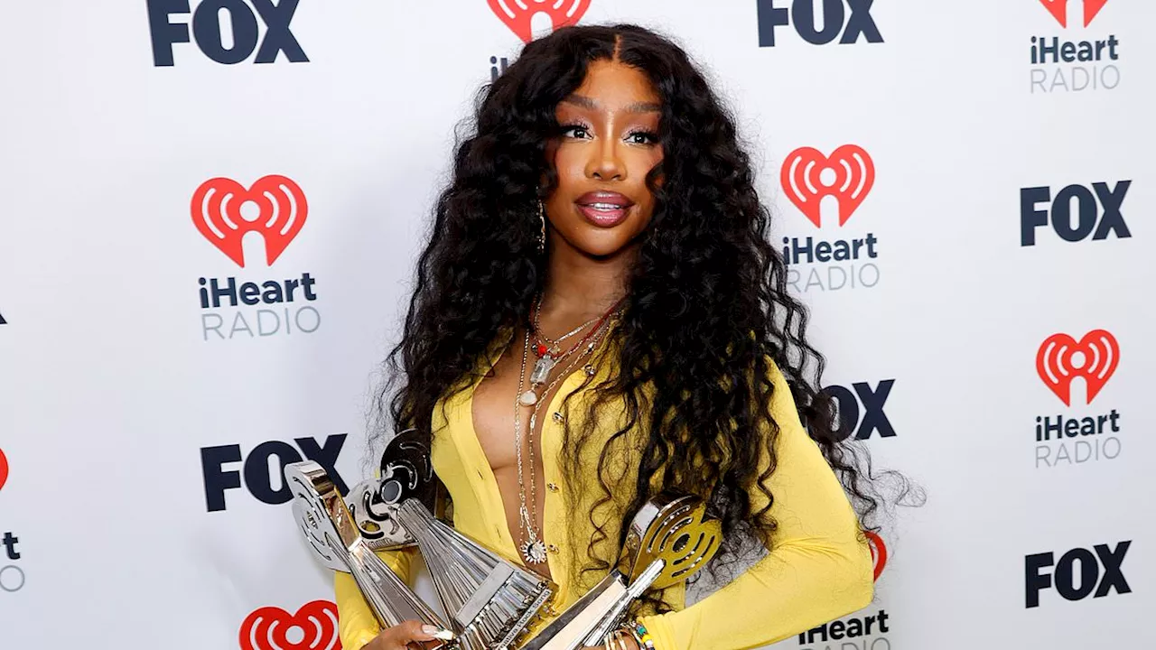 SZA takes home FOUR trophies at iHeartRadio Music Awards in LA while clad in plunging yellow...