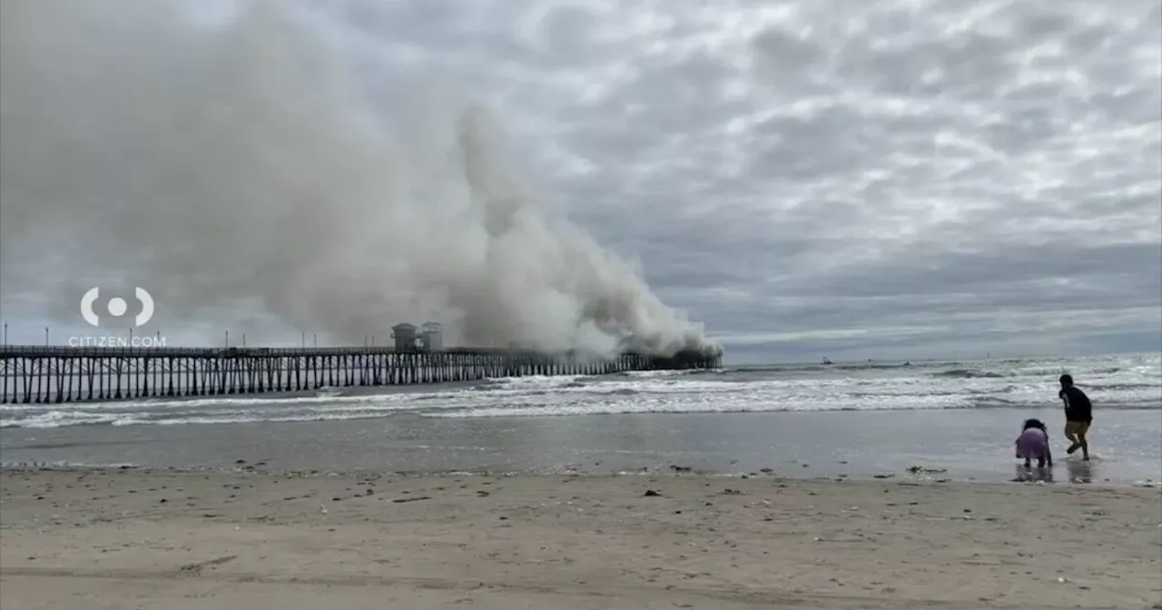 Oceanside pier engulfed in flames. Firefighters work to extinguish blaze