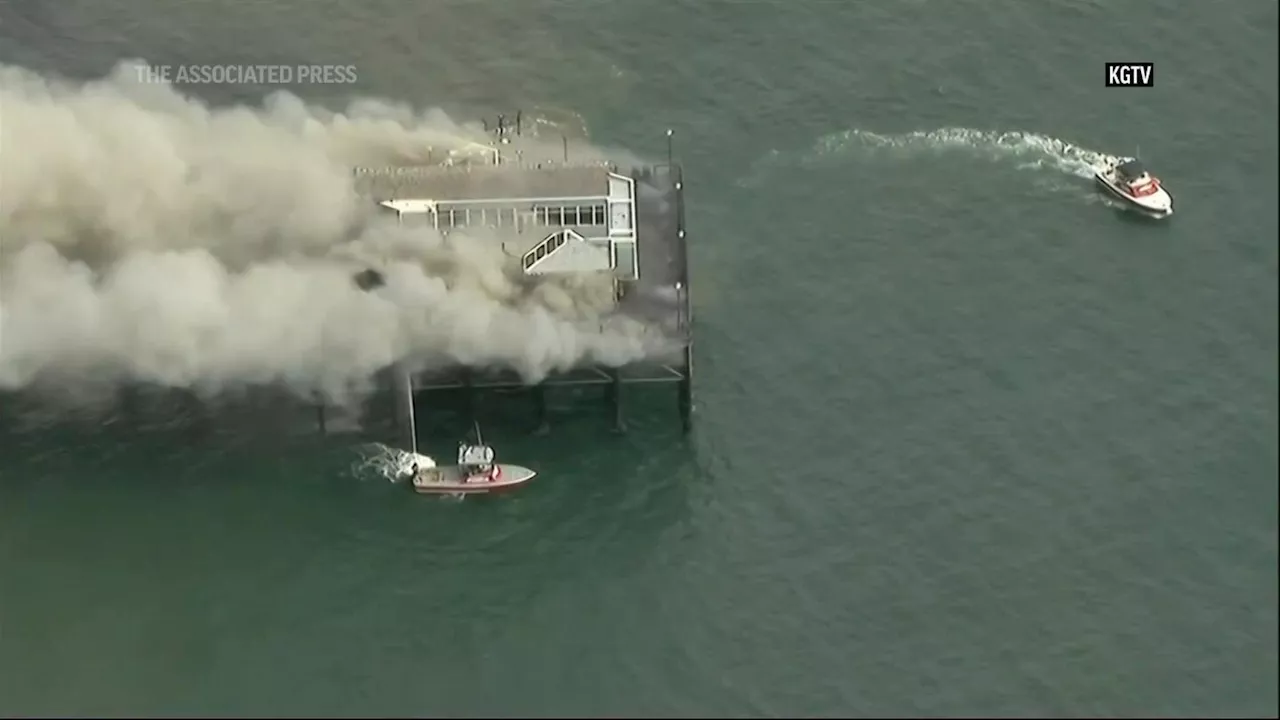 Building at end of Southern California pier catches fire, sending smoke billowing onto beach