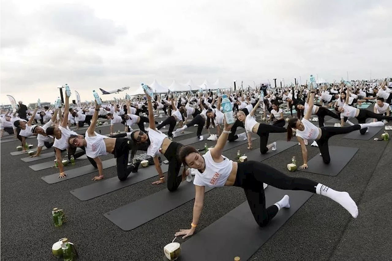 'Feel like a beautiful bird': Hundreds do yoga on main Bangkok airport runway