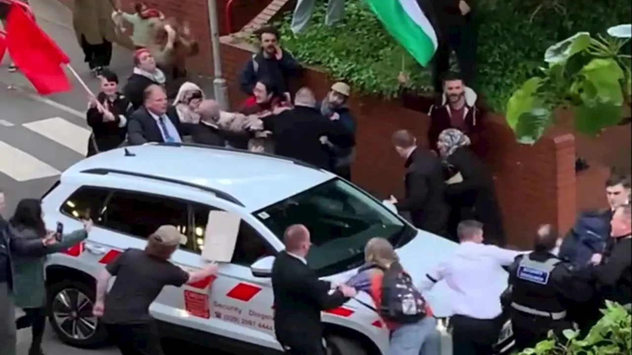 ‘Shrill idiots’ waving Palestinian flags grapple with security as they rush car of Tory MP Jacob Ree...