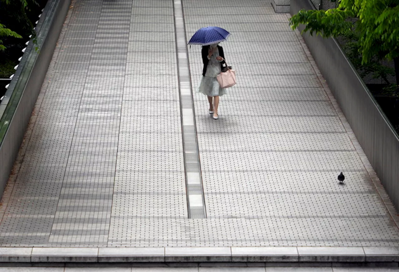 Donna su un ponte nel quartiere degli uffici di Tokyo