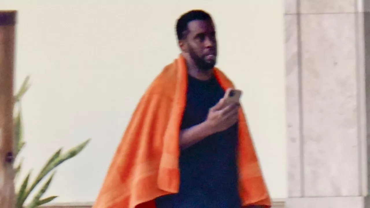 Diddy relaxes by his Miami pool after posting 1998 Victory music video clip that depicts him running...