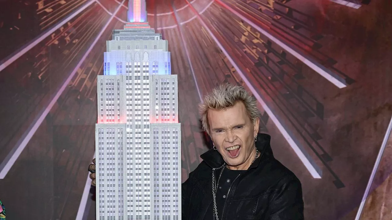 Billy Idol, 68, lights the Empire State Building red and blue in honor of the 40th anniversary of...