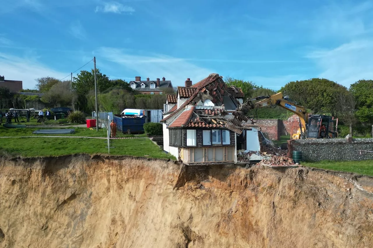 Drone footage shows demolition of a farmhouse left hanging over cliff edge after landslide