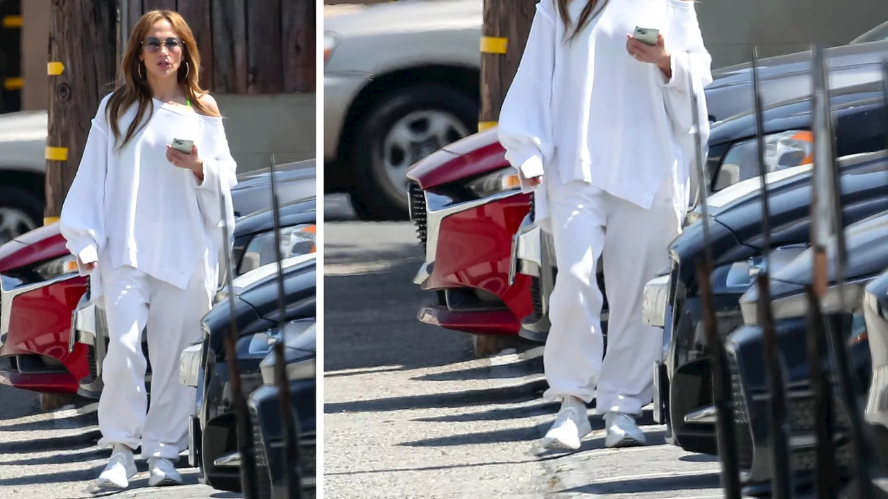 Jennifer Lopez combina pantalones, blusa oversize y tenis blancos para un día caluroso de mayo 2024