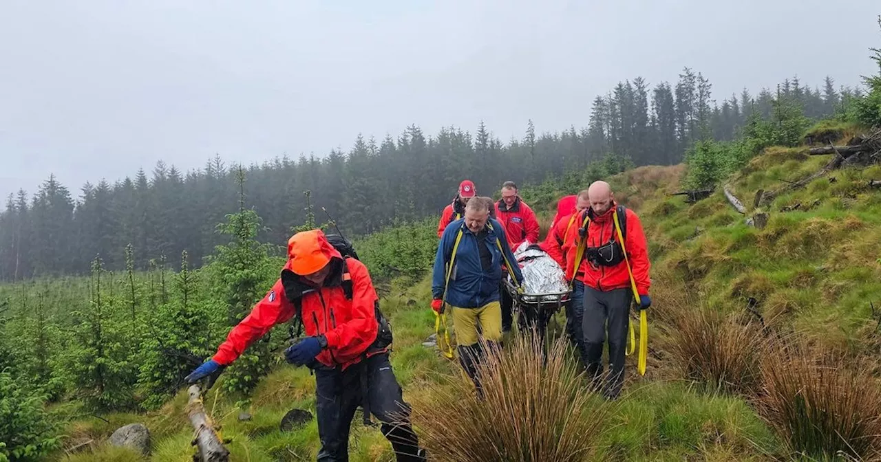 Mountain rescue team stretcher walker off hill