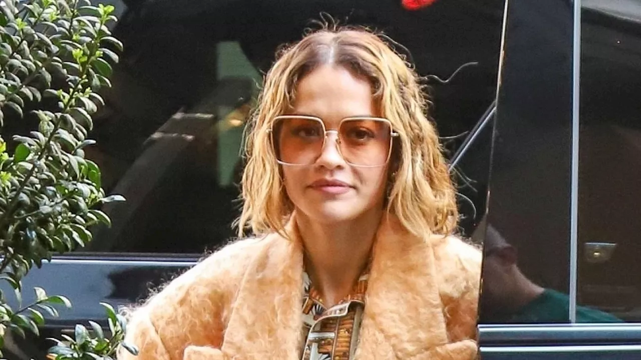 Rita Ora stuns in a sweeping orange coat and matching co-ord as she attends a fitting in New York...