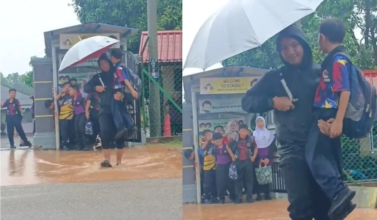 [Video] Demi Elak Kasut Basah Terkena Air Bertakung, ‘Pak Guard’ Sanggup Angkat Setiap Murid