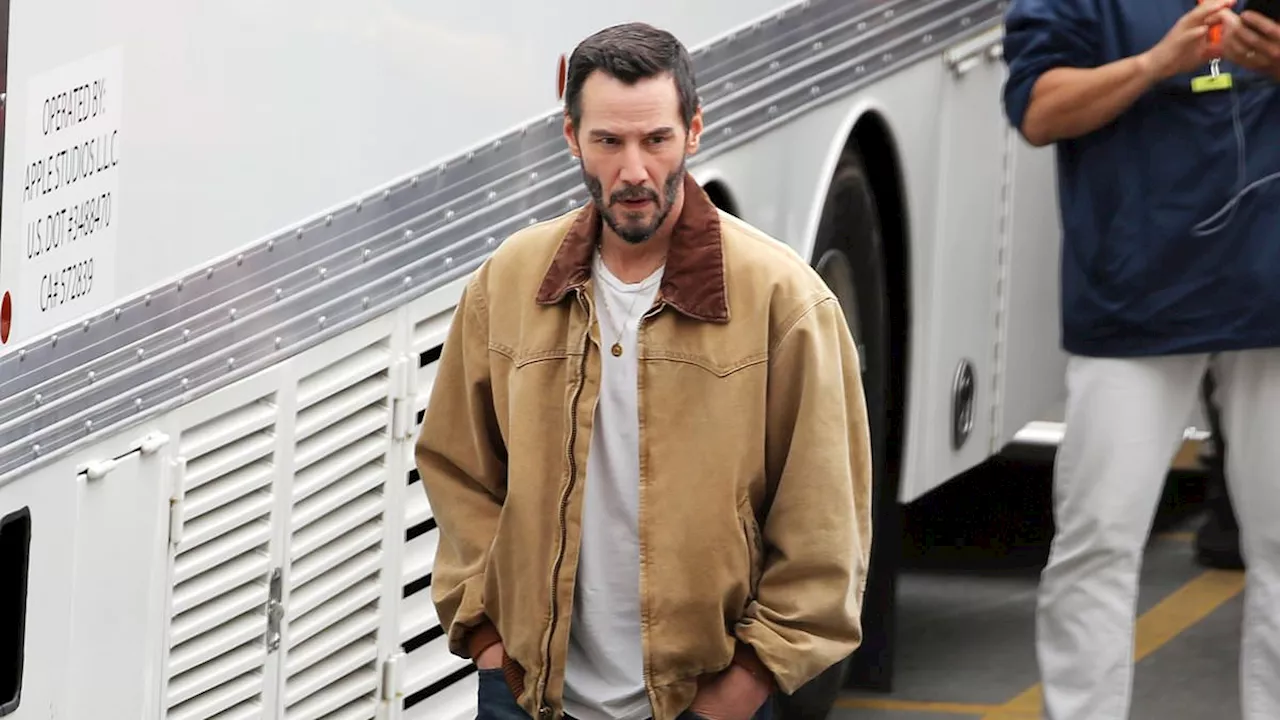 Keanu Reeves, 59, enjoys a cigarette and can of Coca-Cola as he takes a break doing reshoots for new...