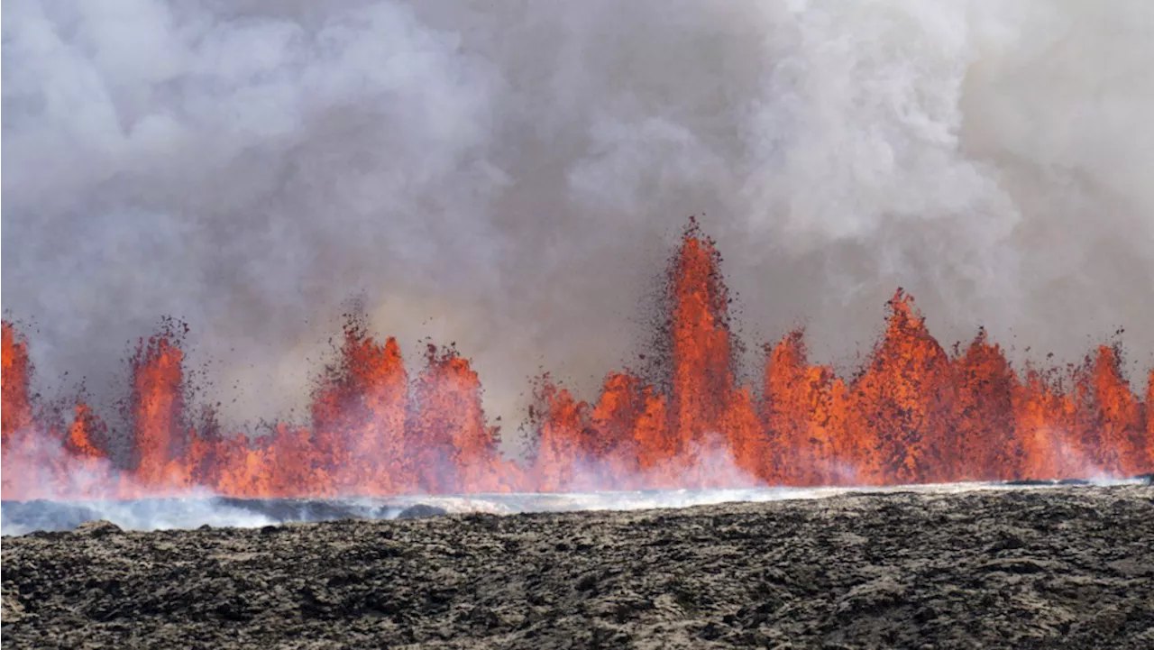 An Iceland volcano spews red streams of lava toward an evacuated town