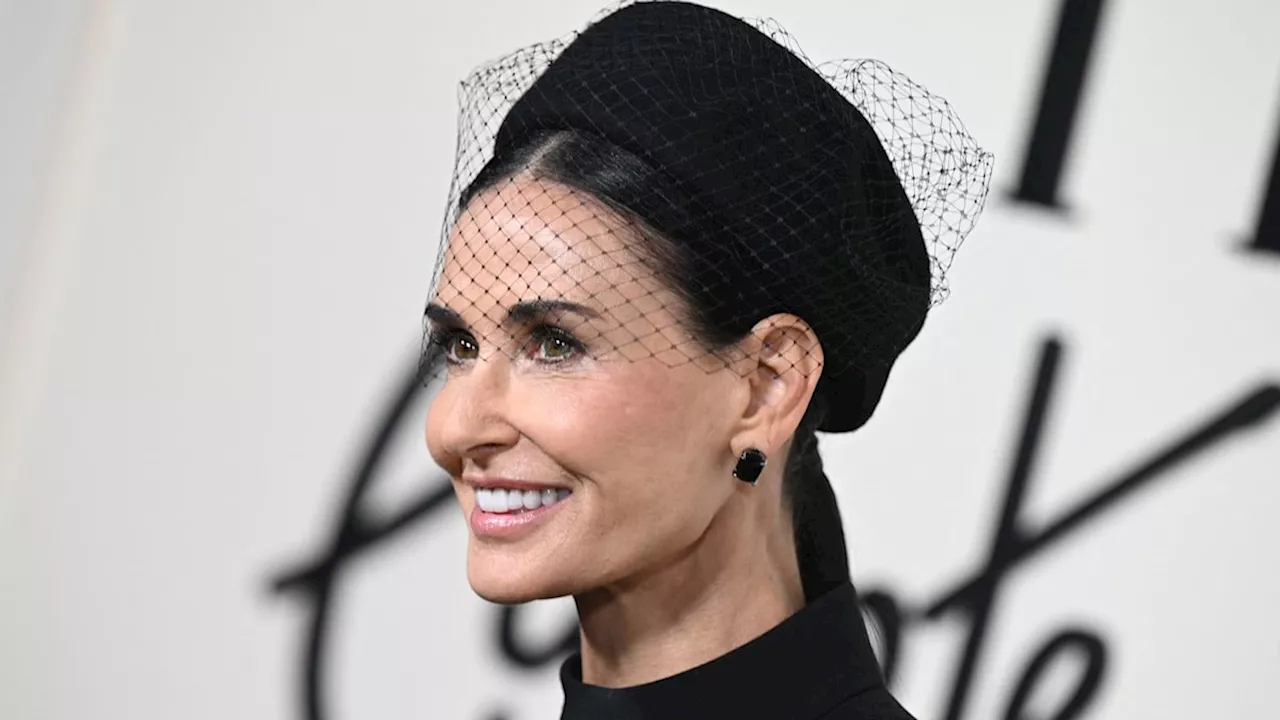 Demi Moore is a gothic beauty in waist-defining trousers and dramatic facial veil