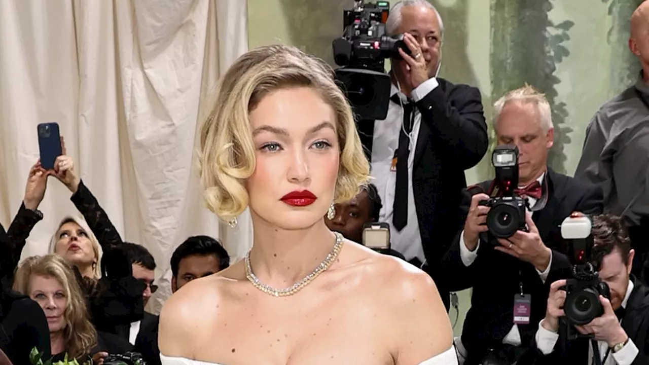 Gigi Hadid exudes old Hollywood glamour with strapless floral ballgown and coiffed bob as she walks...