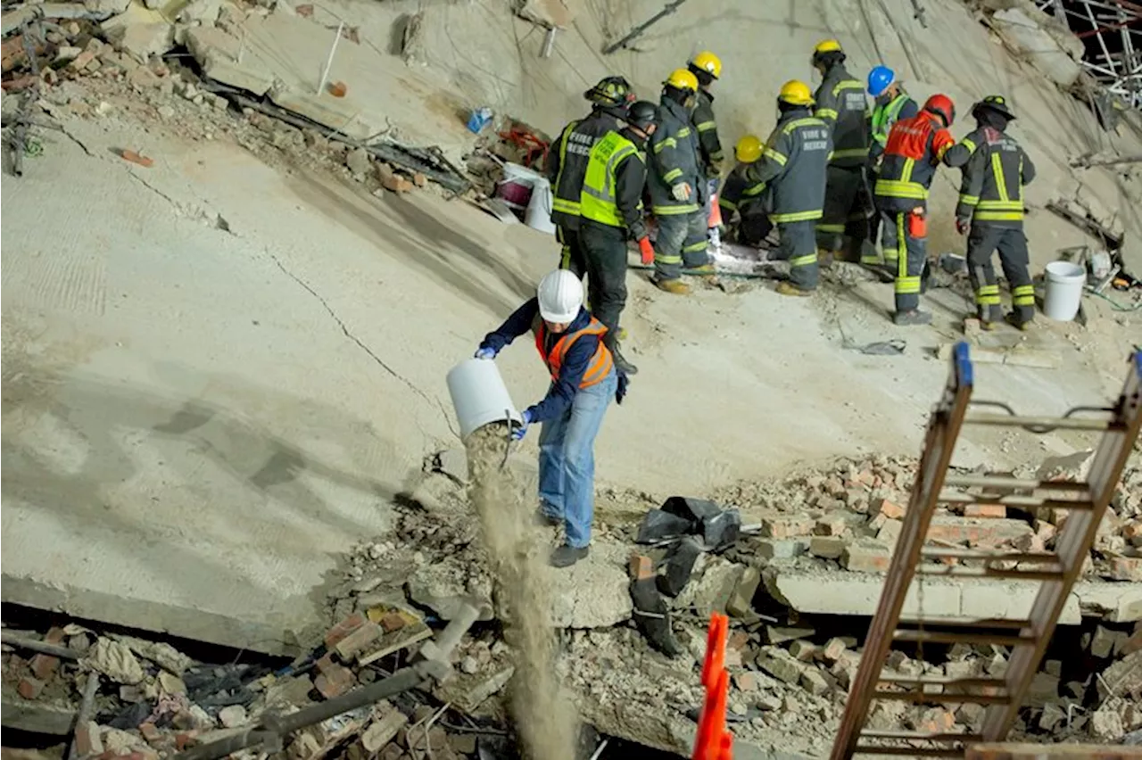 Rescue workers communicate with people trapped in collapsed George building