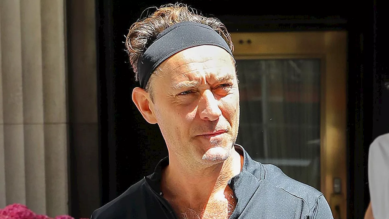 Jude Law, 51, wears a dodgy headband and cuts a sporty figure as he steps out in NYC with his leggy...