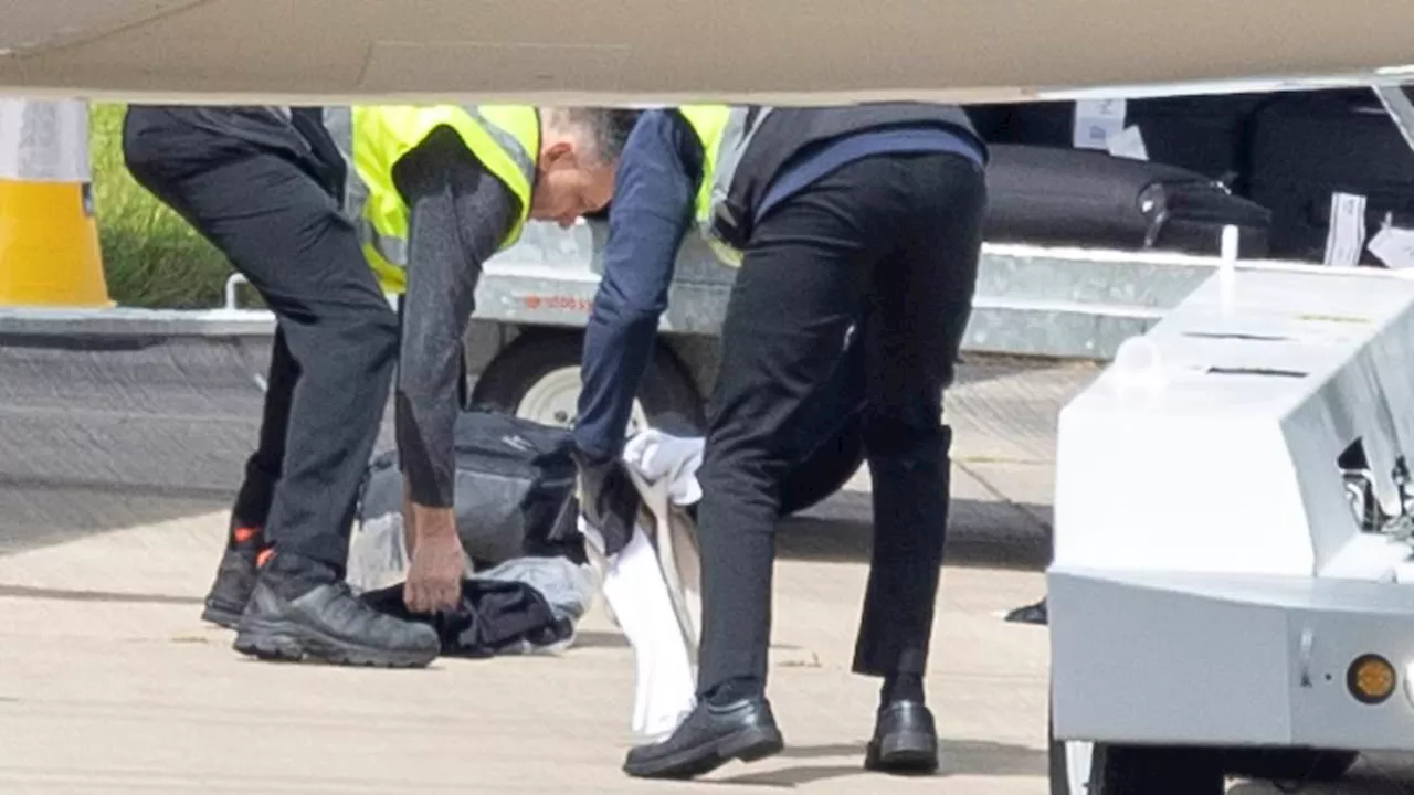 England players' clothes spill onto the tarmac after bungling Birmingham Airport baggage handlers...