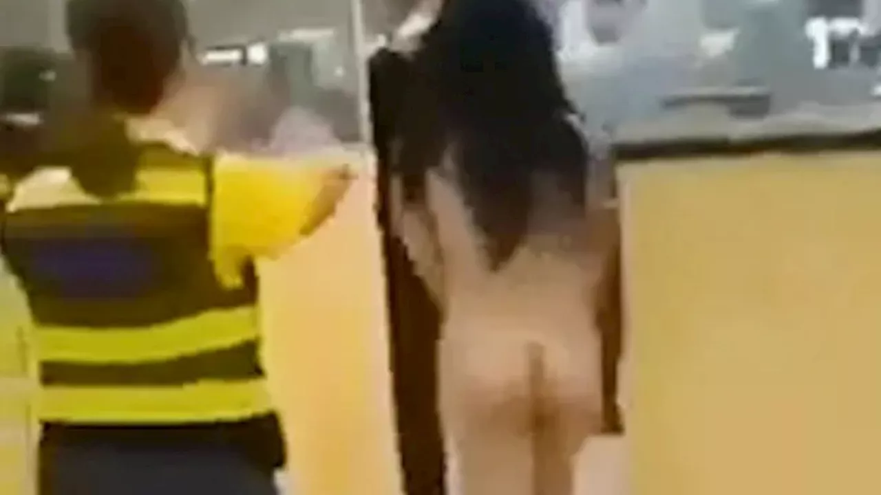 Shocking moment furious female passenger struts NAKED through airport security in protest over fee to use...