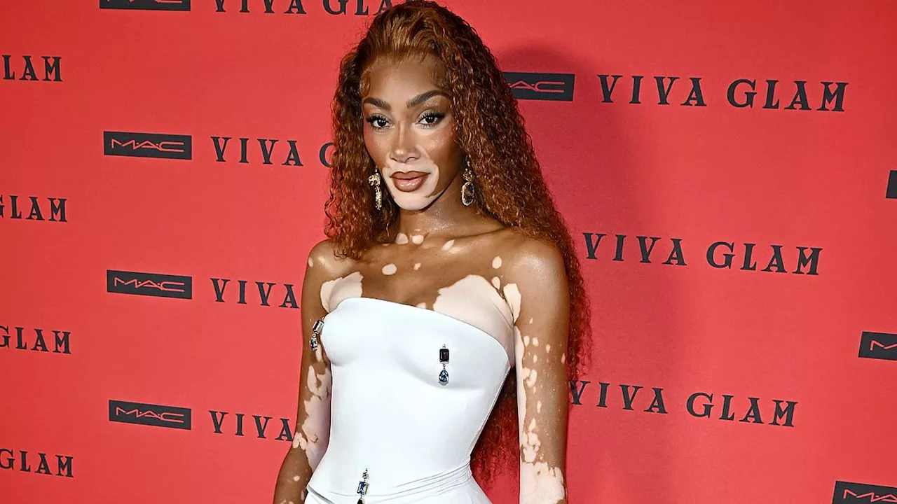 Winnie Harlow wears tiny white mini skirt with matching bodice featuring jeweled nipple piercings...