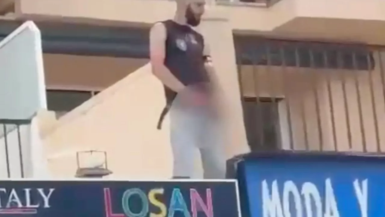 Shock moment drunk Germany fan URINATES from first-floor balcony onto Majorca street ahead of opening...