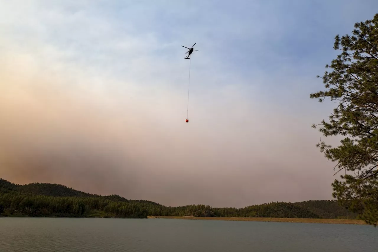 Cooler temps and rain could help corral blazes that forced thousands to flee New Mexico village