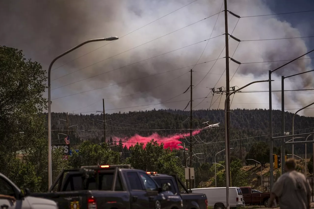 Cooler temps and rain could help corral blazes that forced thousands to fee New Mexico village