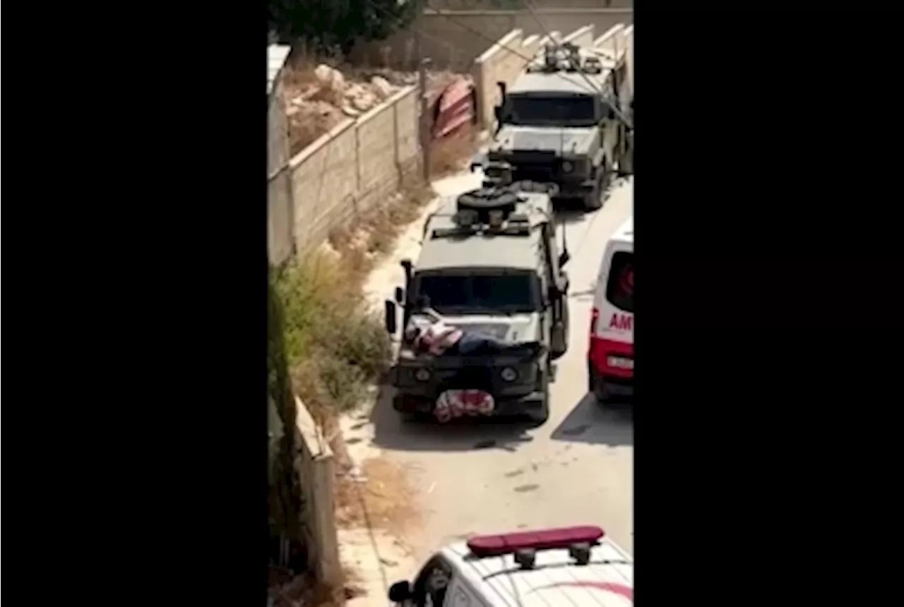 Israeli forces strap wounded Palestinian to jeep during raid