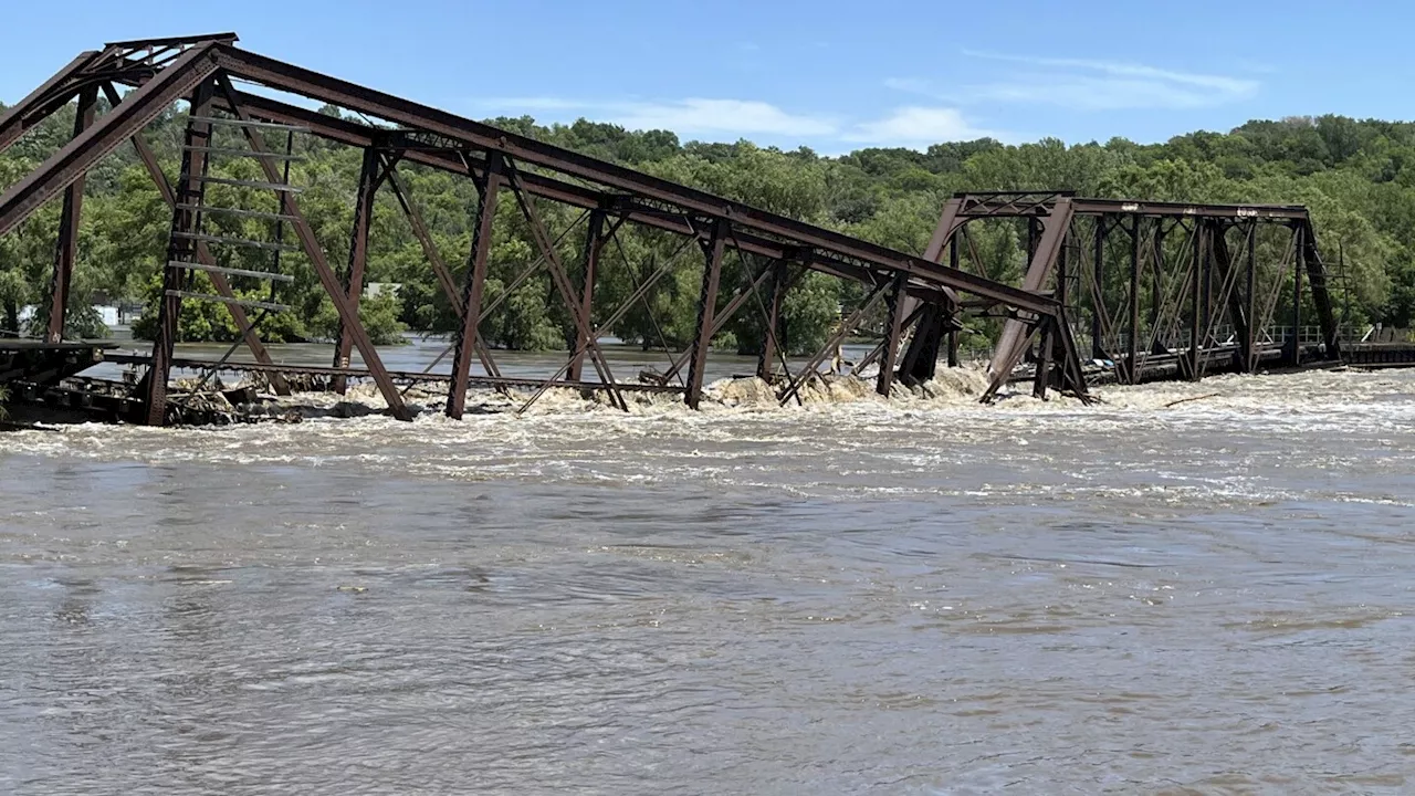 Midwest flooding collapses bridge, sends water surging around a dam