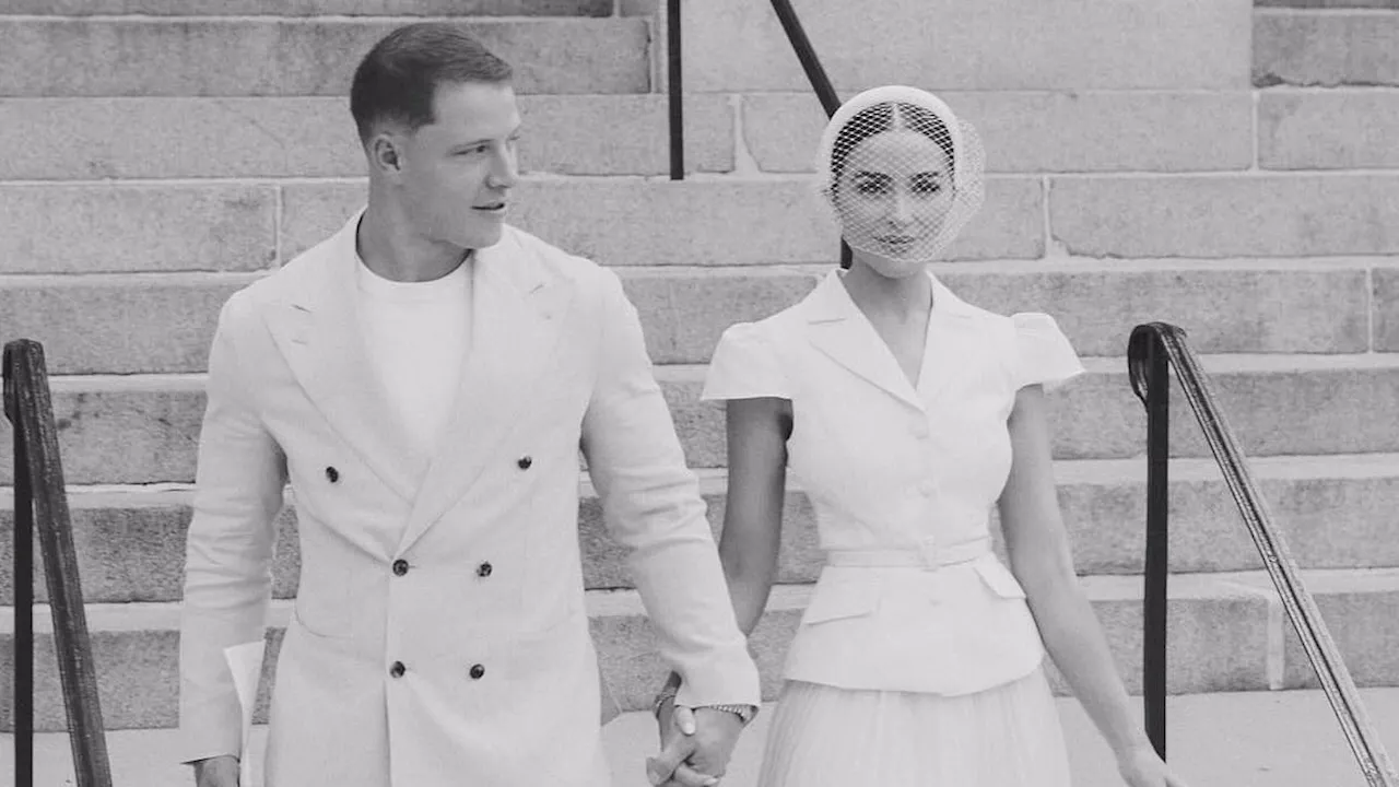 Olivia Culpo and Christian McCaffrey sign their marriage license as they both look chic in white...