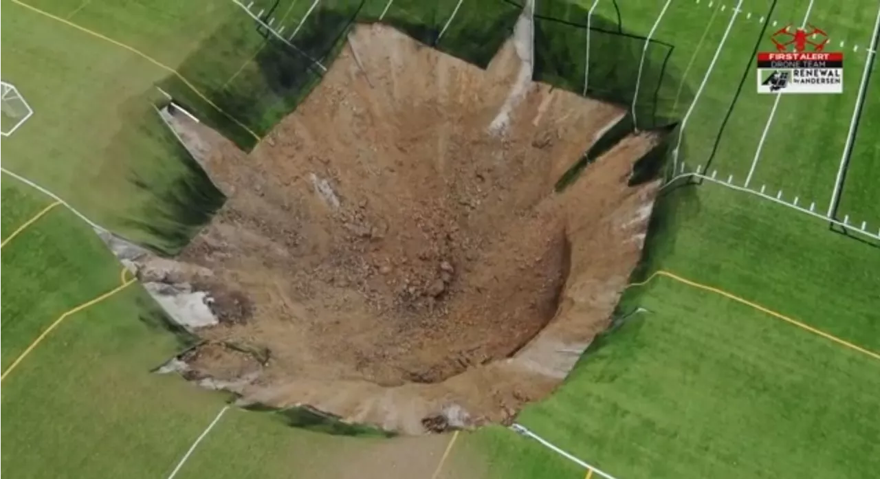 Moment giant 15 metre deep sinkhole opens in the middle of a football field