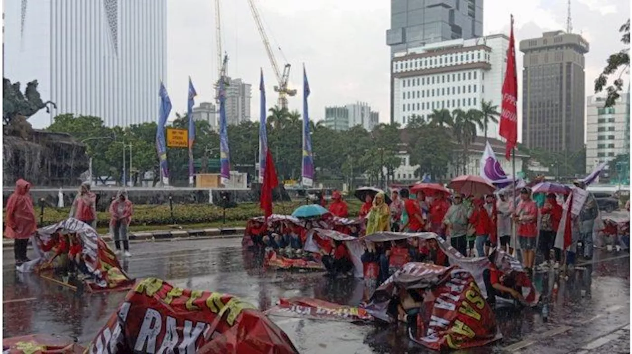 Berlindung Pakai Payung & Spanduk, Massa Demo Tolak UU Tapera Bertahan di Bawah Guyuran Hujan Deras