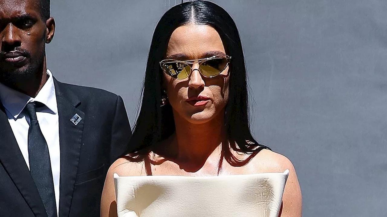 Katy Perry models a striking cream dress with folded sides in NYC... after putting on flesh-flashing...