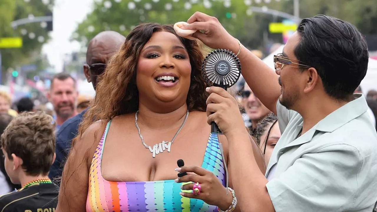 Lizzo flashes her midriff in clinging rainbow-colored Yitty two-piece as she attends Pride festival...